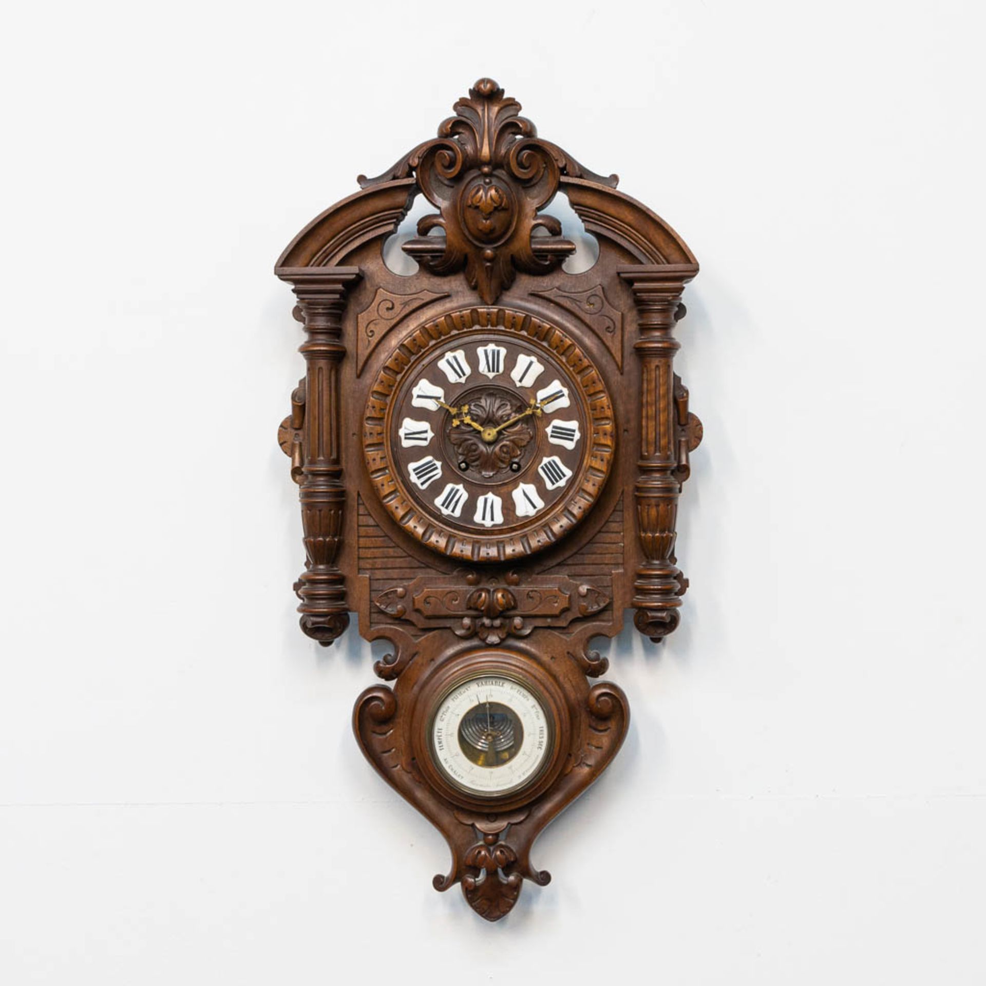 A sculptured wood cartel clock, with barometer