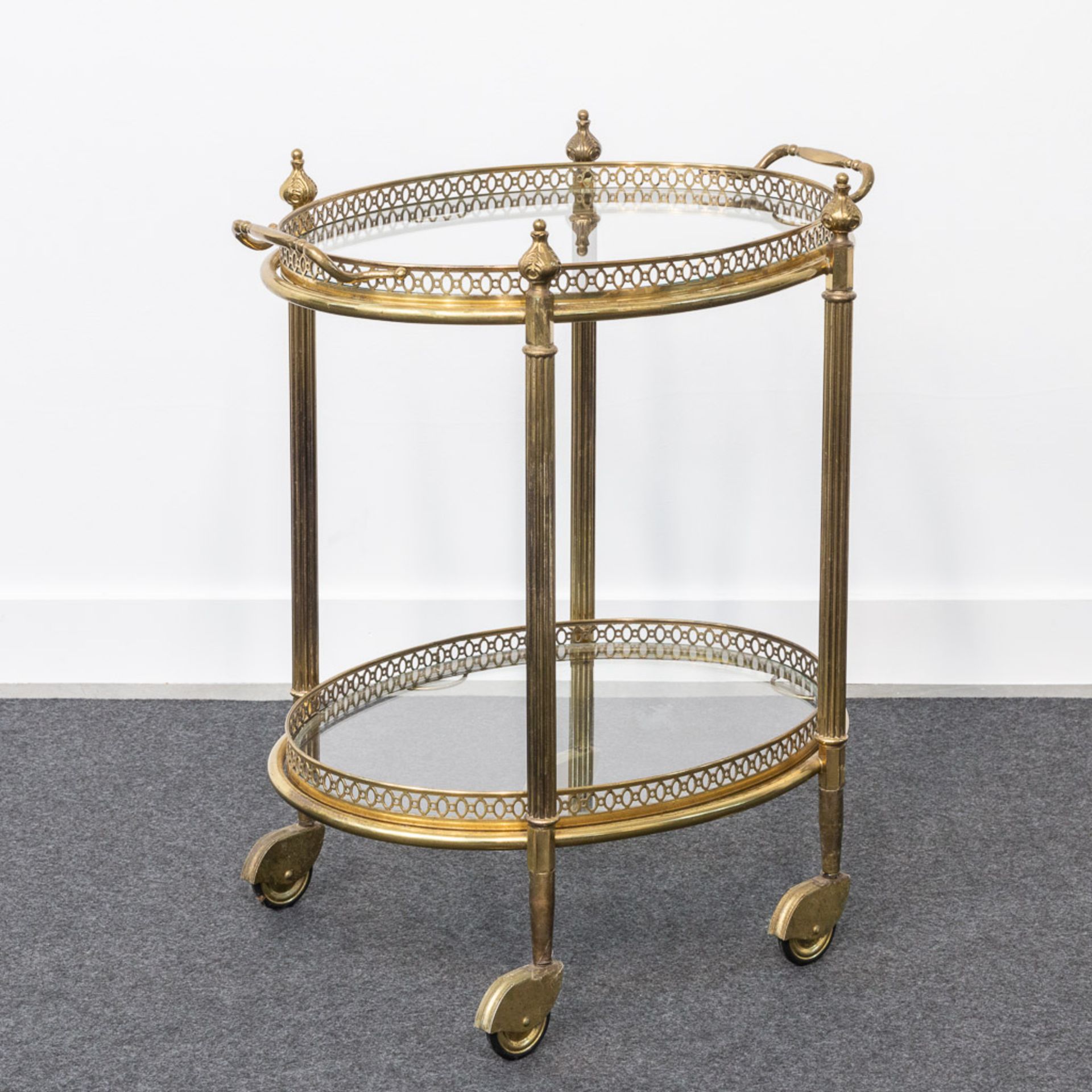A metal and glass side table on wheels, in the style of Maison Jansen.