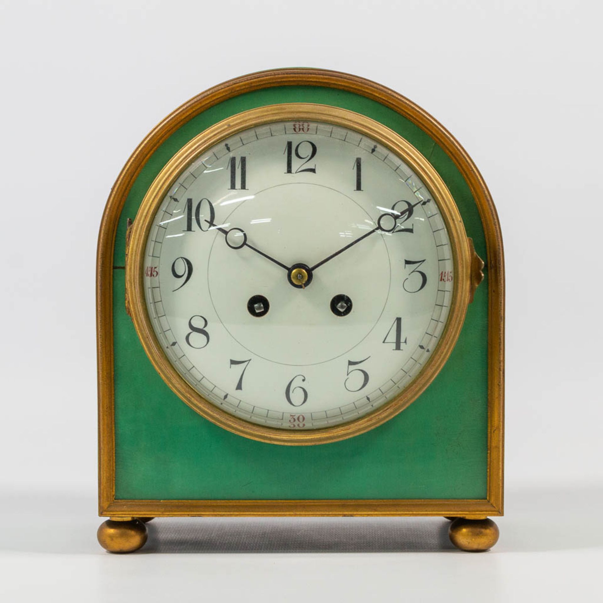 An elegant table clock made of a green lacquered wood case mounted with ormolu bronze, made in Franc