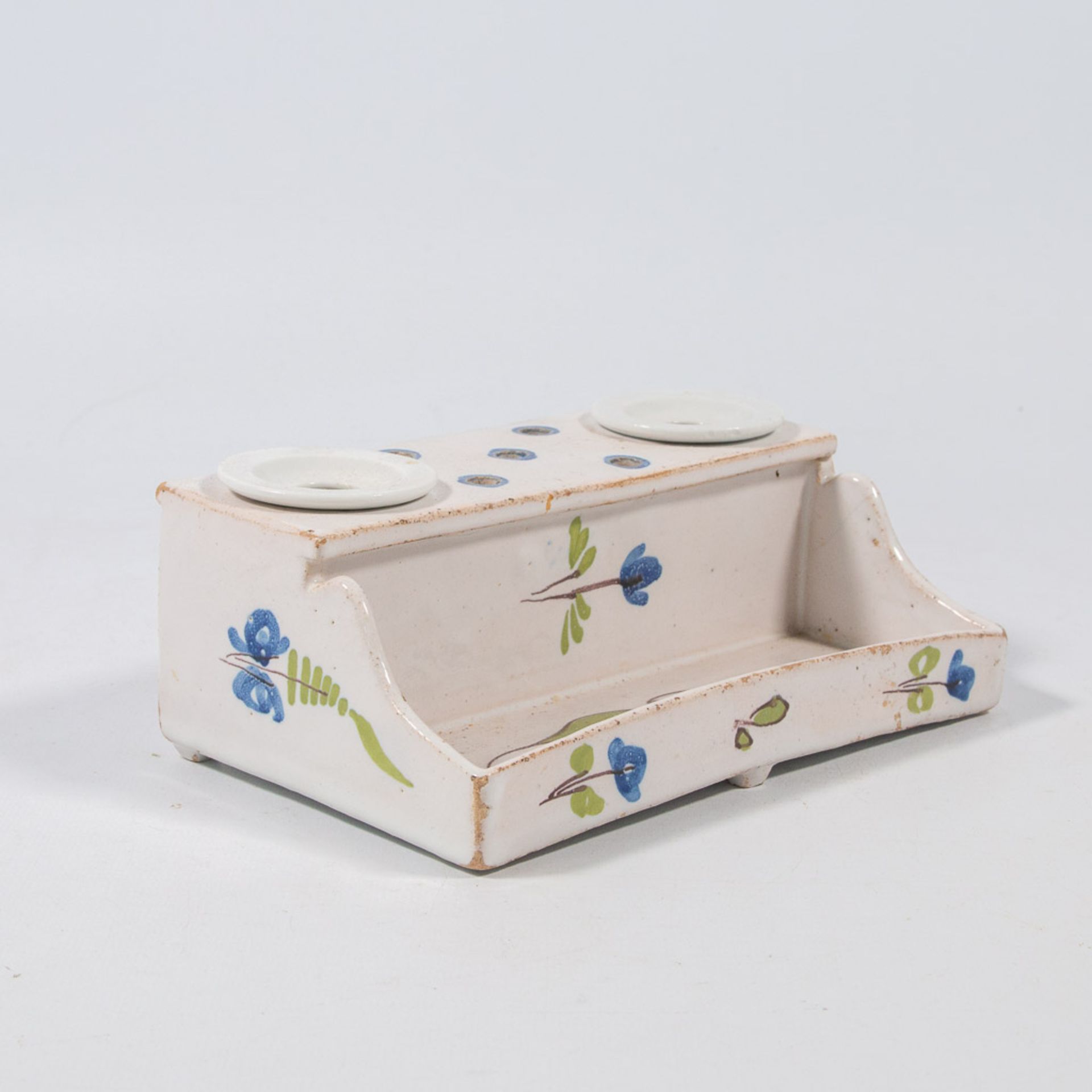 A ceramic ink pot with floral decor.