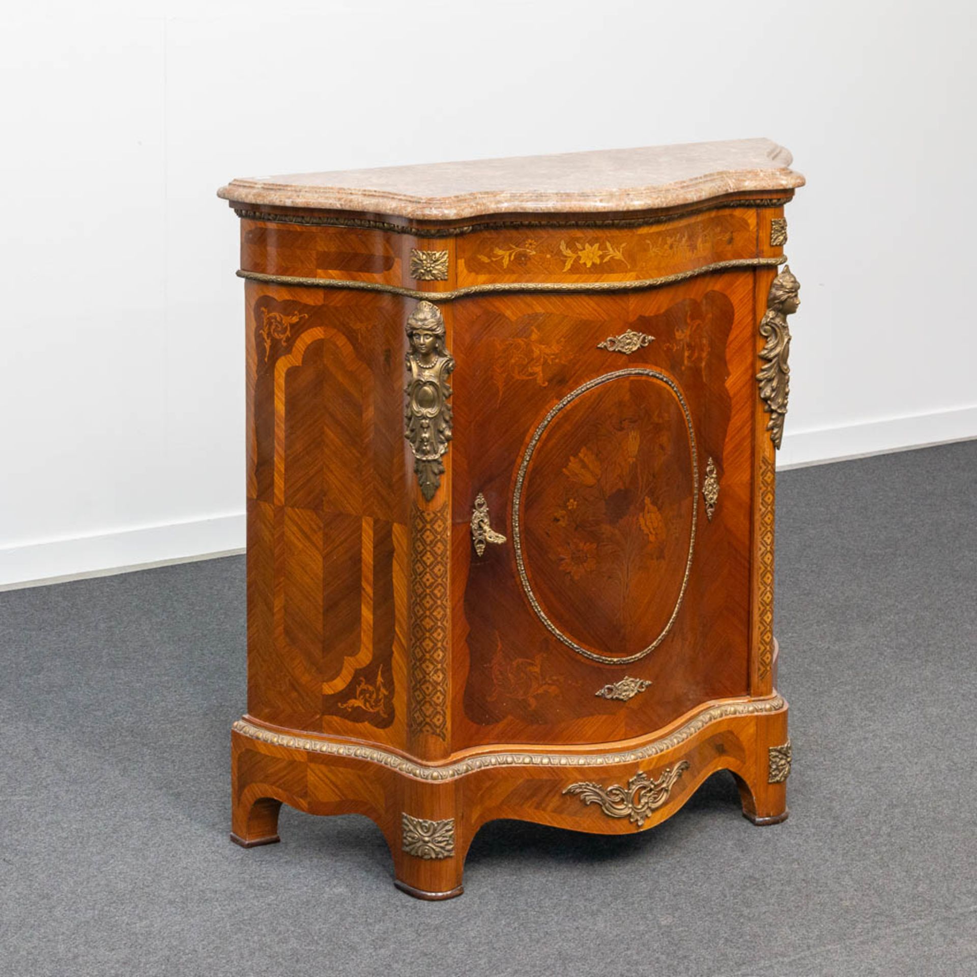 A curved commode inlaid with marquetry with marble top