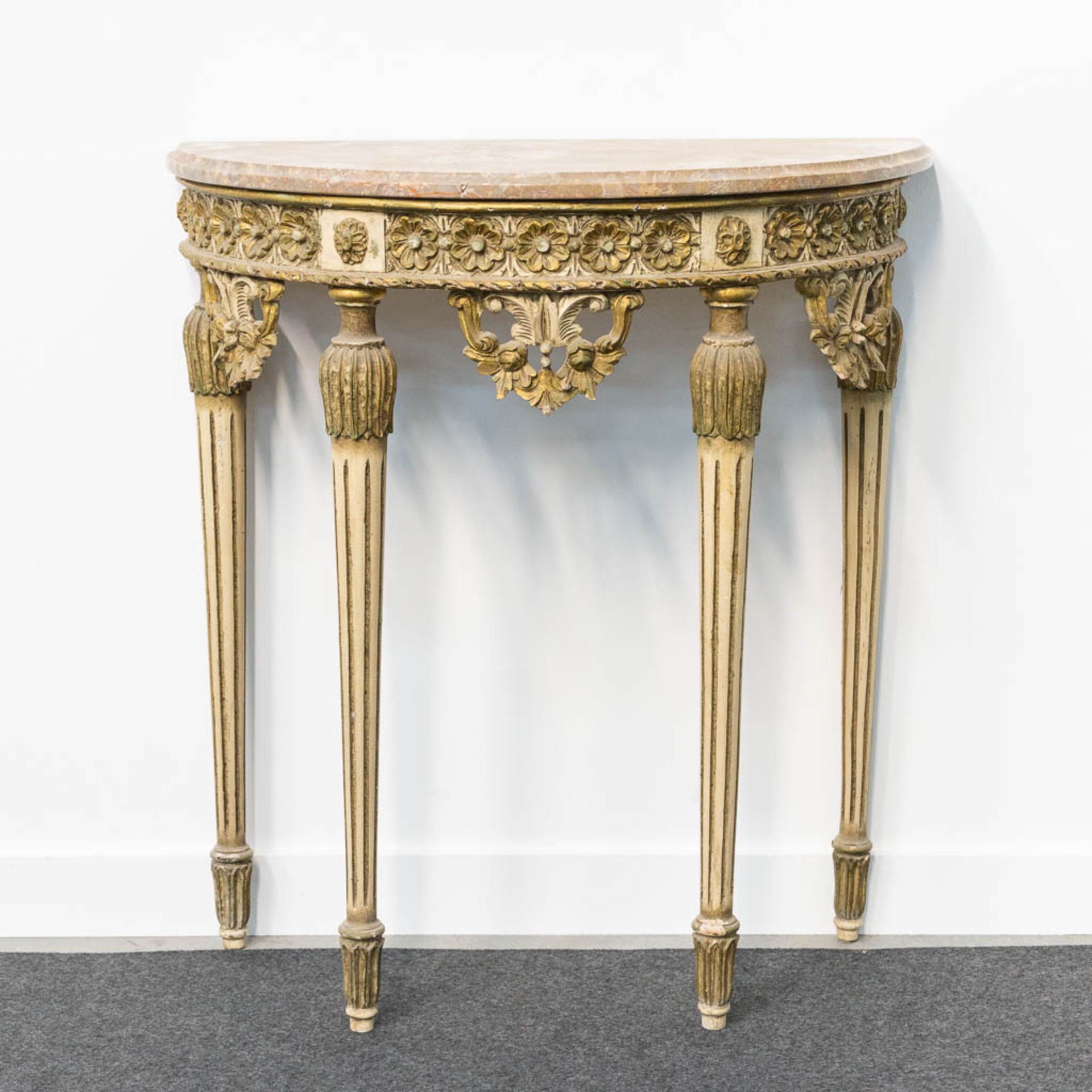 A Louis XVI style console table with marble top and sculptured wood decorations.
