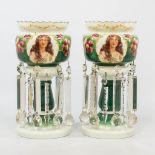 A pair of glass lustres, with hand-painted flowerdecor and printed images of ladies. (34,5 x 17 cm)