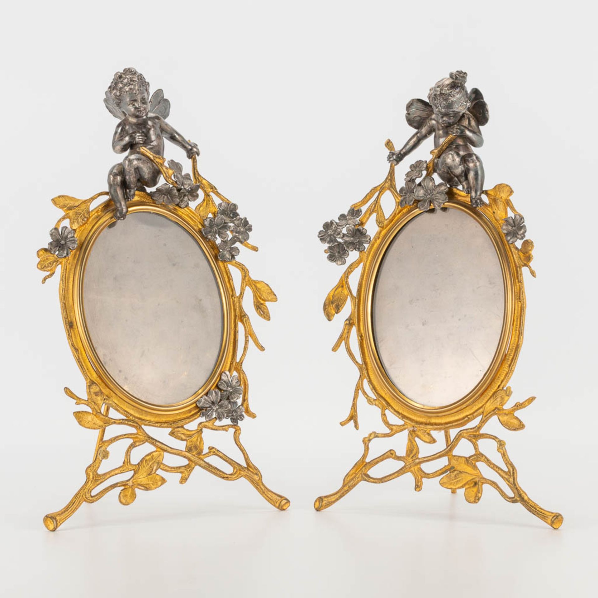 A pair of picture frames made of gold-plated bronze with silver-plated putti. 19th century. (17 x 29
