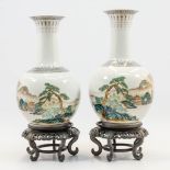 A pair of Chinese vases with hand-painted decor of landscapes with pine trees on a wood base, Republ