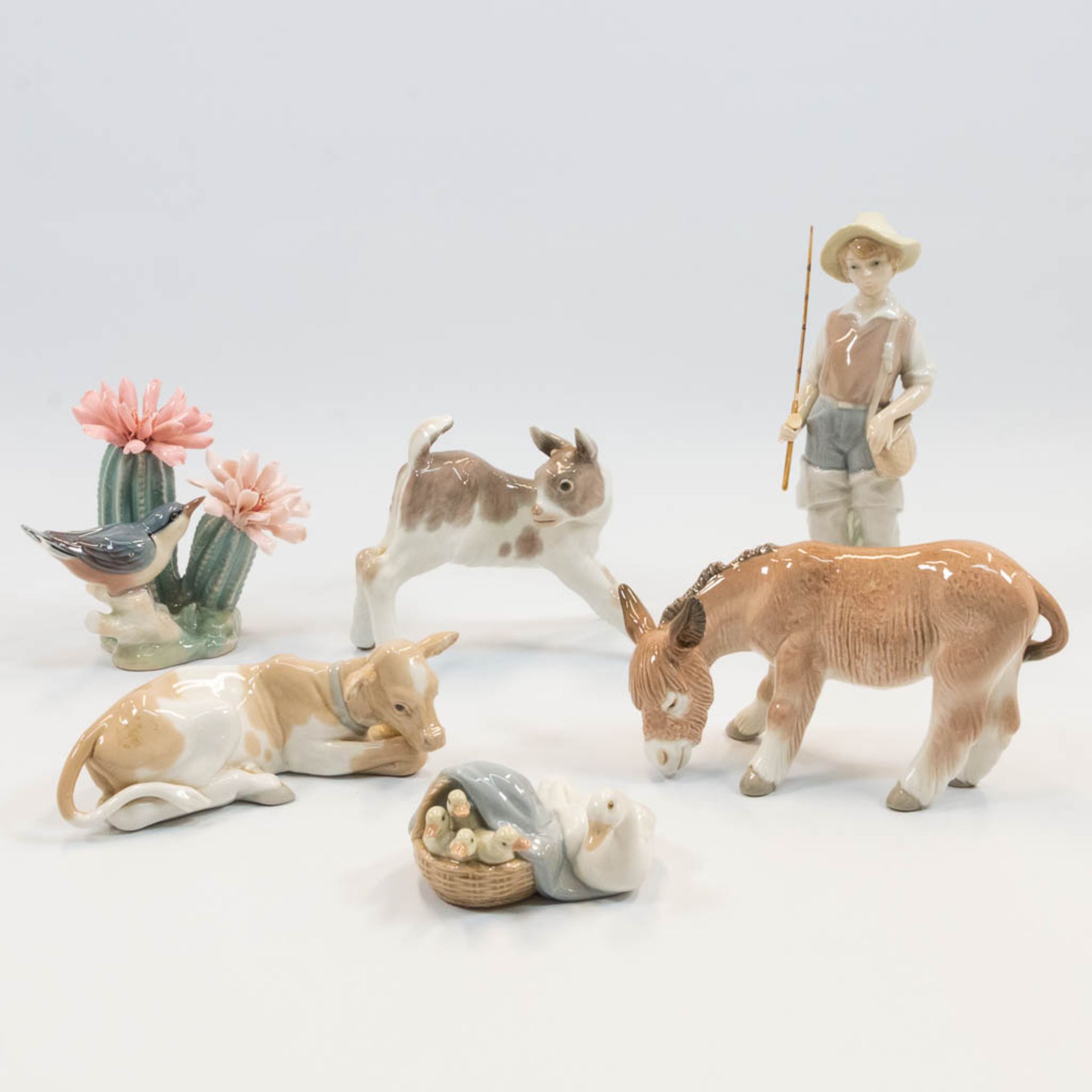 A collection of 6 porcelain figurines of animals and a fisherman, marked Lladro, made in Spain. (22 