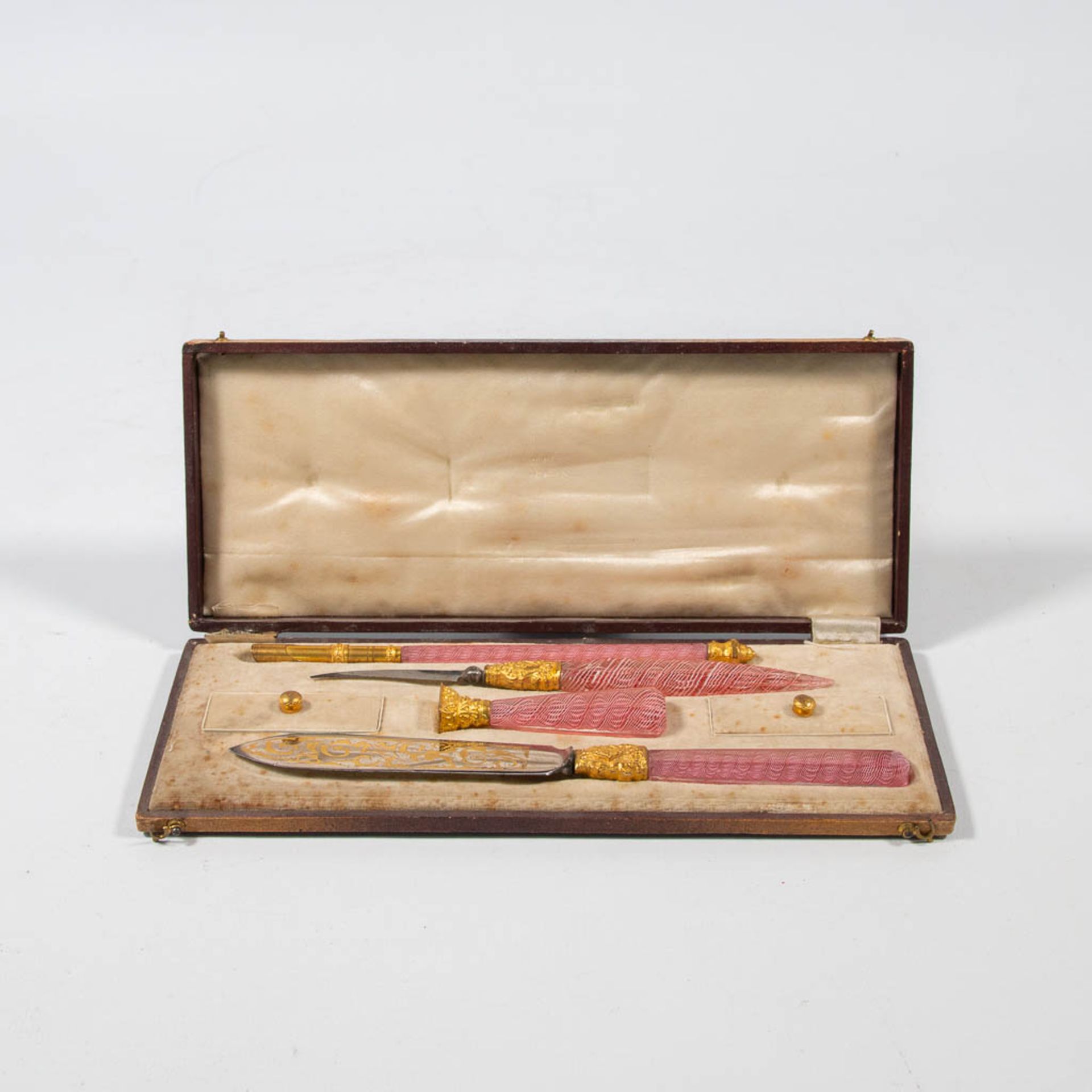 A collection of writing instruments in a case with glass handles, and made in Murano, Italy around 1