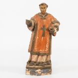 A sculptured wood statue of a holy figurine, with book. 18th century. (7,5 x 11 x 23 cm)