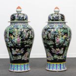 A huge pair of Famille Noir porcelain Chinese vases with a decor of immortals and playing children.