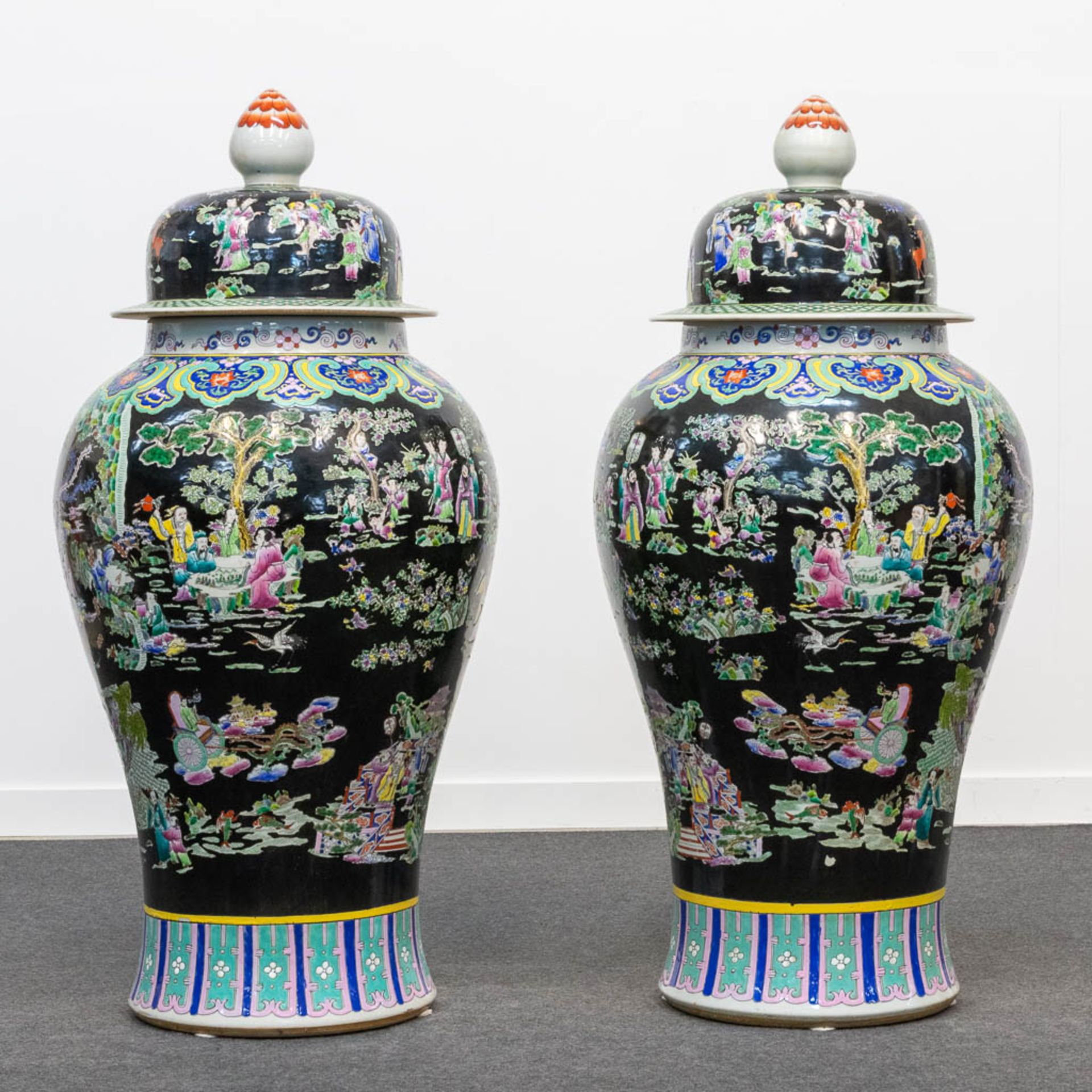 A huge pair of Famille Noir porcelain Chinese vases with a decor of immortals and playing children. 