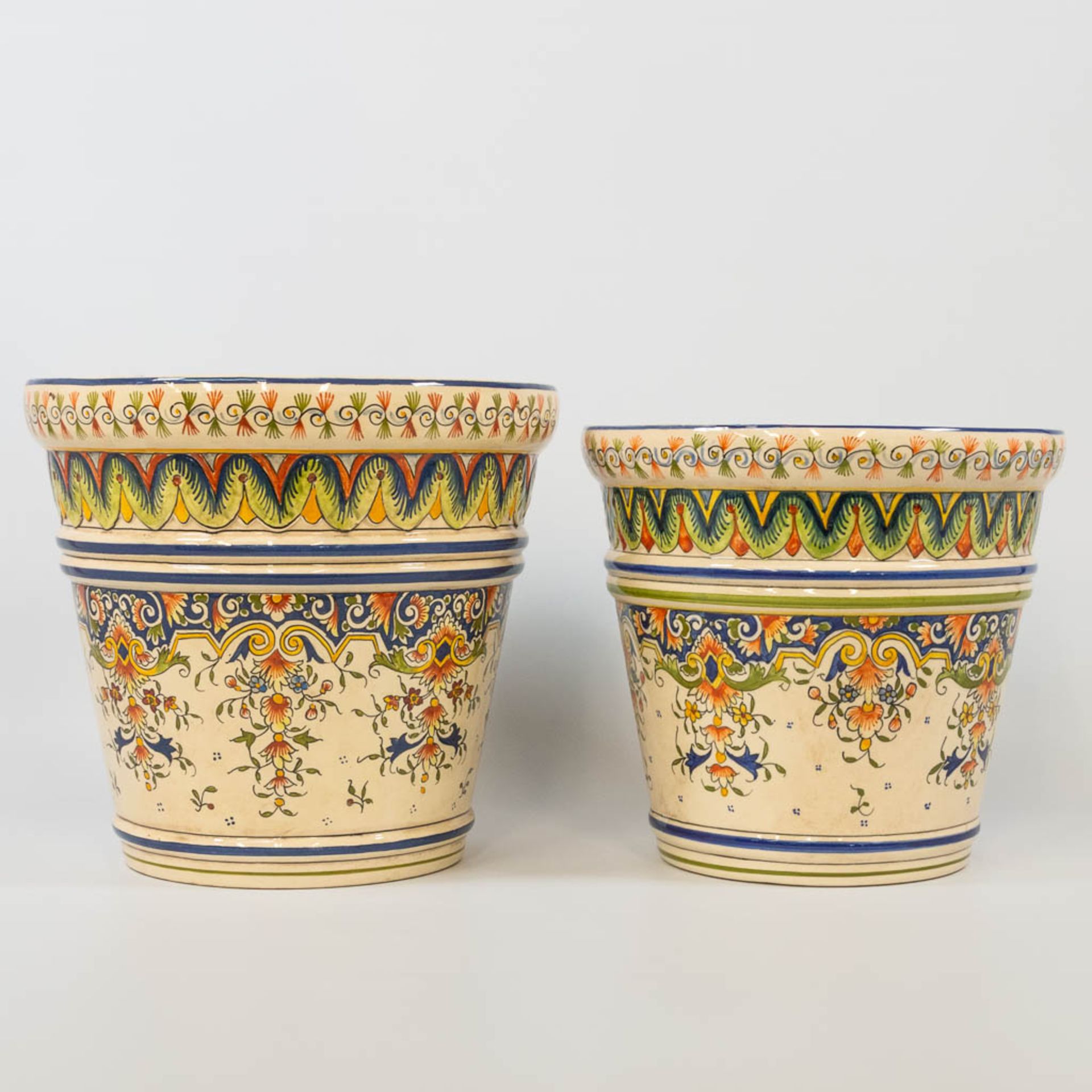 A collection of 2 cache-pots in two sizes with hand-painted decor, made of faience in Rouen, France.