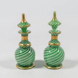 A pair of decanters in glass, with mostly green, white and gold, made in Murano, Italy around 1900.