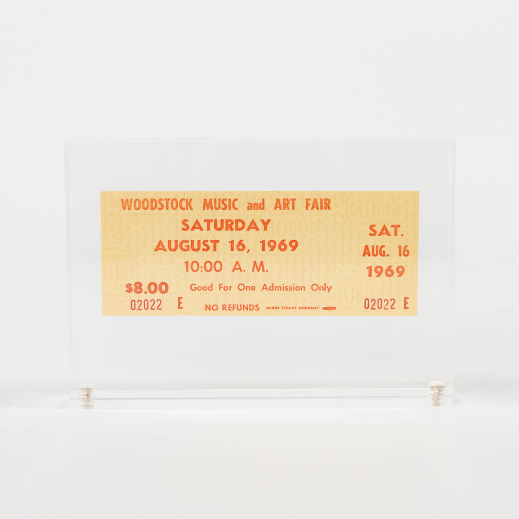 A Woodstock Ticket, Saturday August 16, 1969. Ticket with unused tear strip and stored in an acrylic