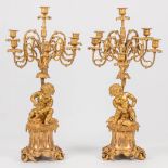 A pair of neoclassical candelabra decorated with putti, playing with pets. 19th century. (30 x 33 x