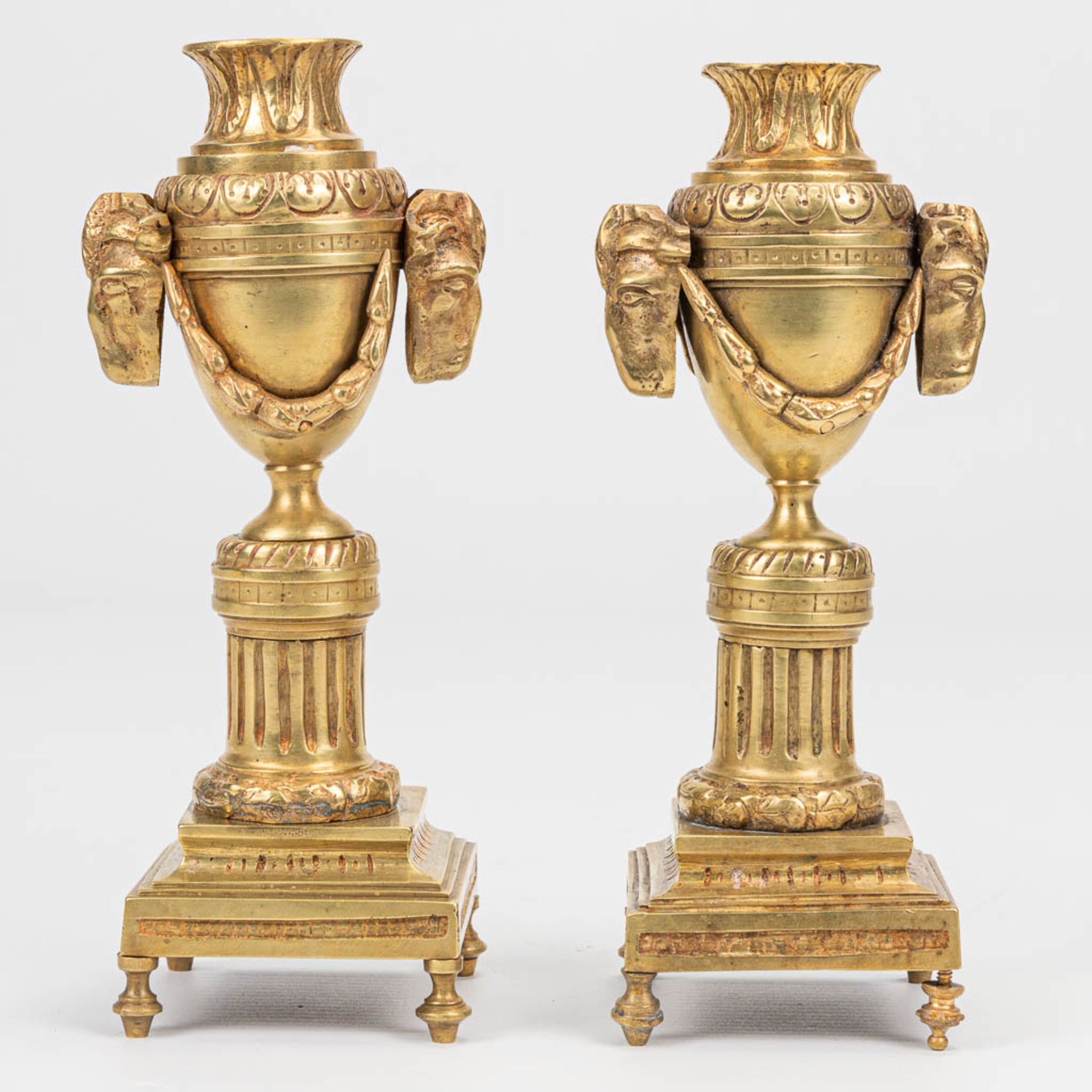 A pair of candlesticks with reversible candle holders and ram's heads in Louis XVI style. (7 x 8 x 1