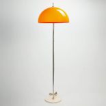 A standing lamp with orange acrylic lamp shade on metal base. Around 1970. (45 x 150 cm)