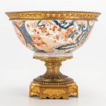 A Japanese Imari porcelain bowl mounted on a bronze base. 19th century. (28,5 x 32 cm)