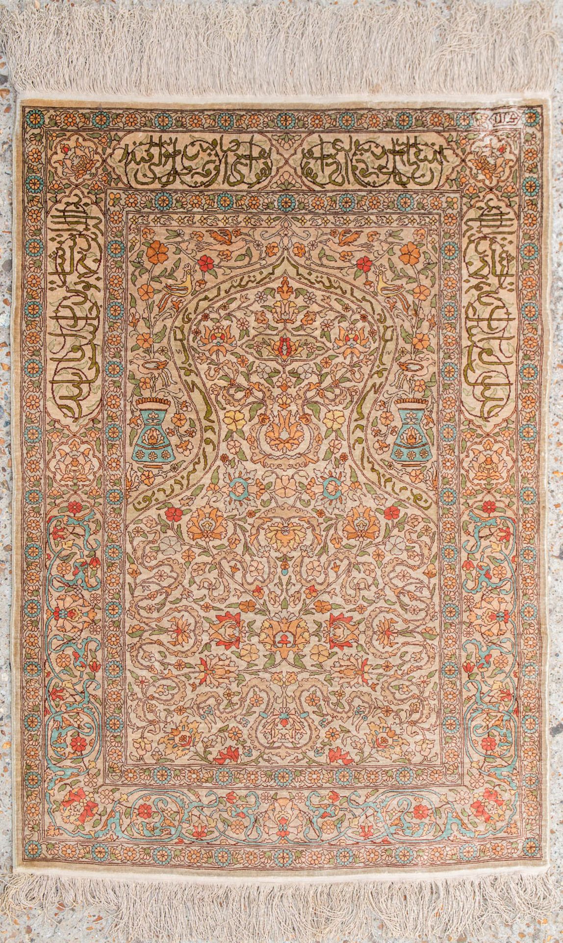 An Oriental hand-made carpet made of silk and signed. (73,5 x 107 cm)