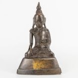 An antique Oriental Buddha, made of patinated bronze. (6 x 11,5 x 18 cm)