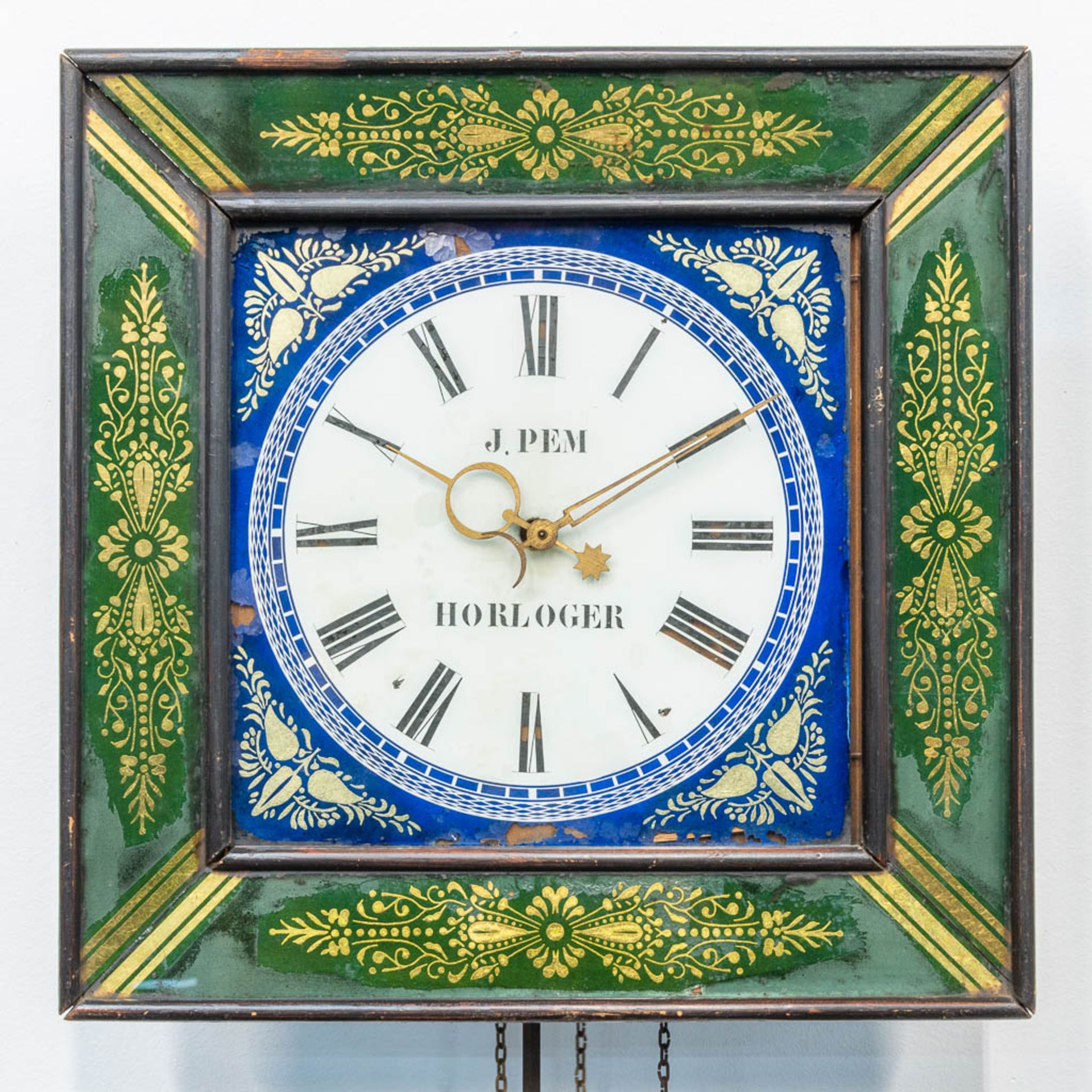 A clock with eglomise reverse glass painting, marked J. Pem Horloger. (12 x 39 x 39 cm)