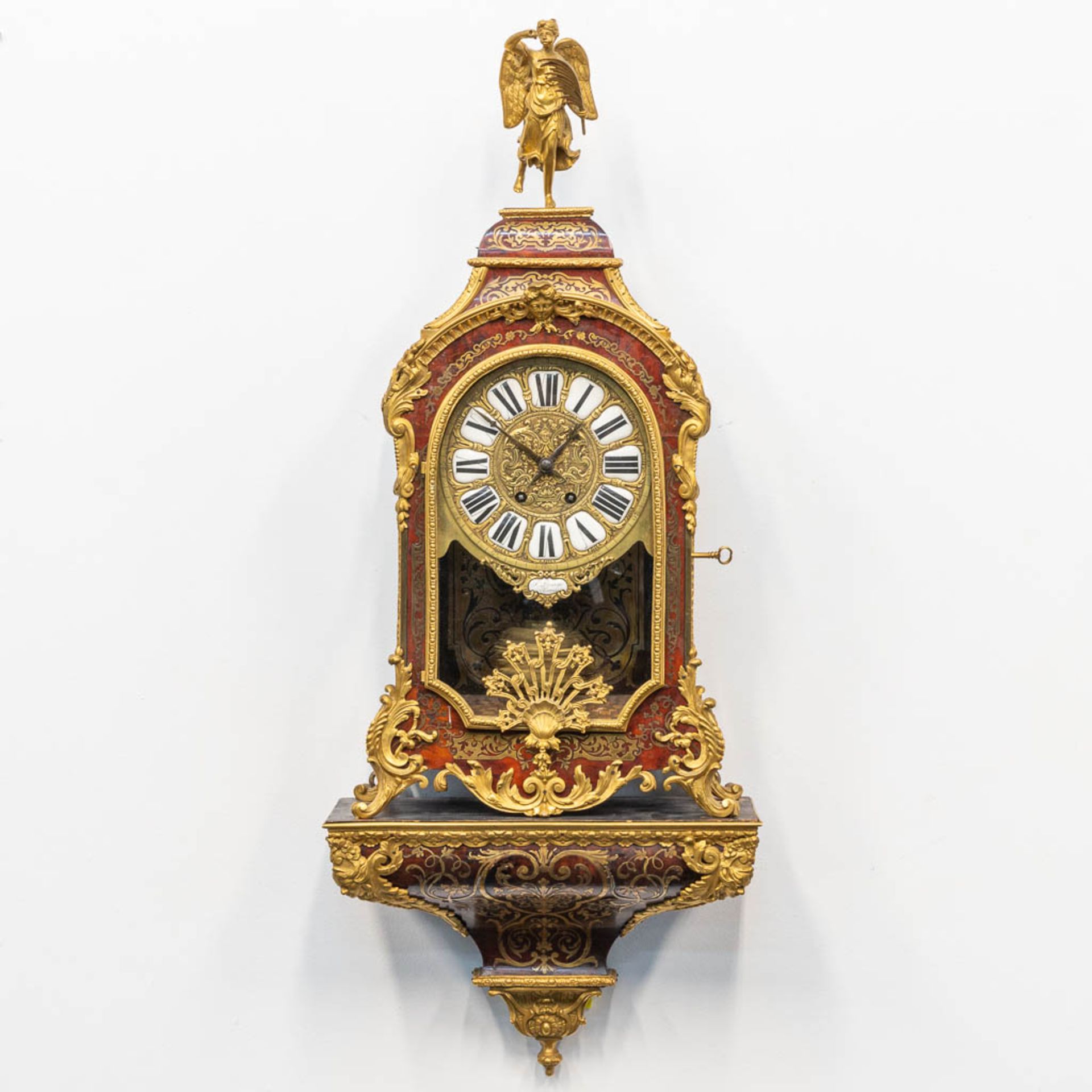 A cartel clock, finished with tortoise shell in a boulle technique, and mounted with gilt bronze. 19