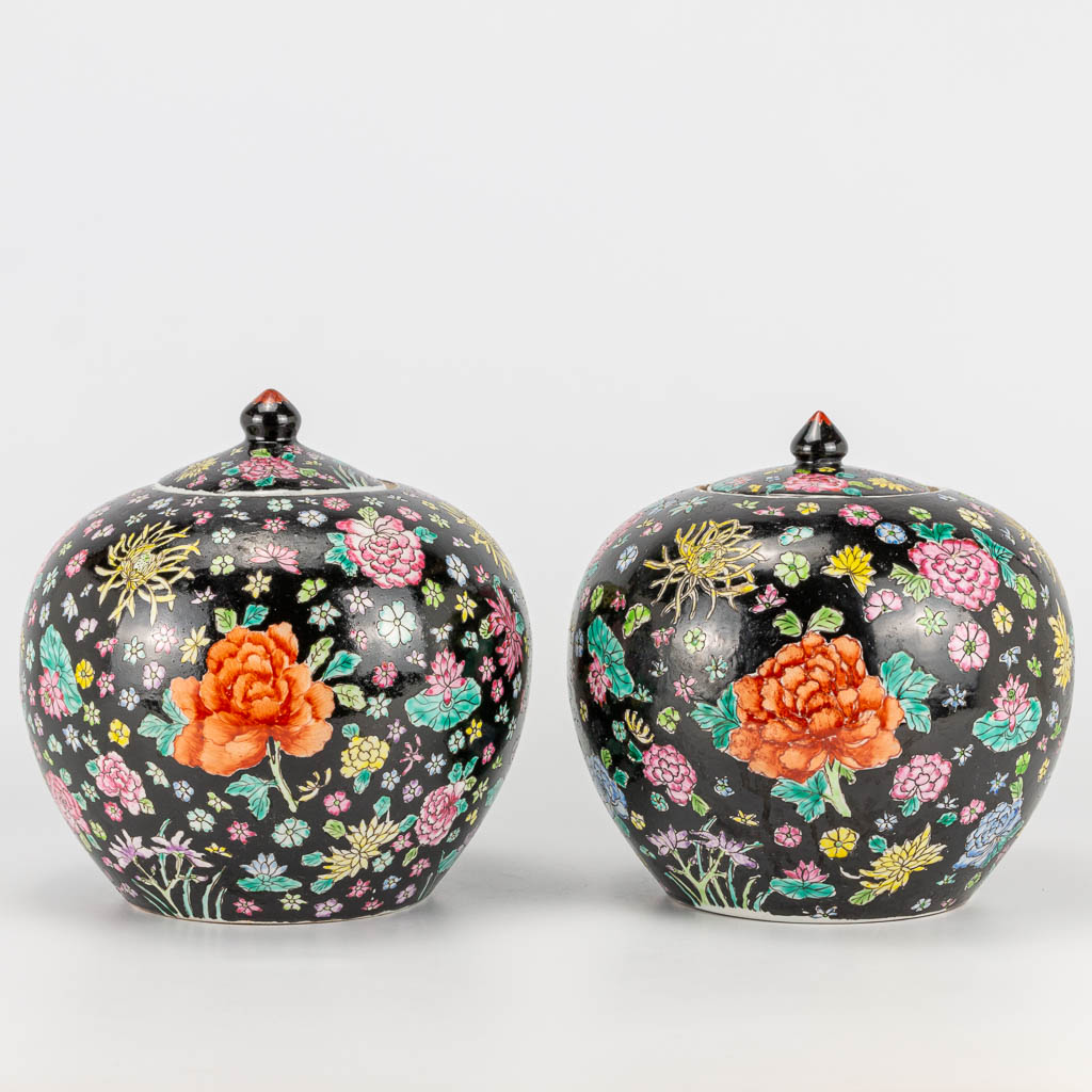 A pair of famille noir Chinese porcelain jars with lid, decorated with flowers. 19th/20th century. (