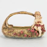 A basket with flowers and an angel, made of faience in Austria and marked Amphora. (17 x 30 x 16 cm)