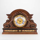 A large sculptured clock made of wood mounted with bronze. 19th century. (18 x 60,5 x 43 cm)