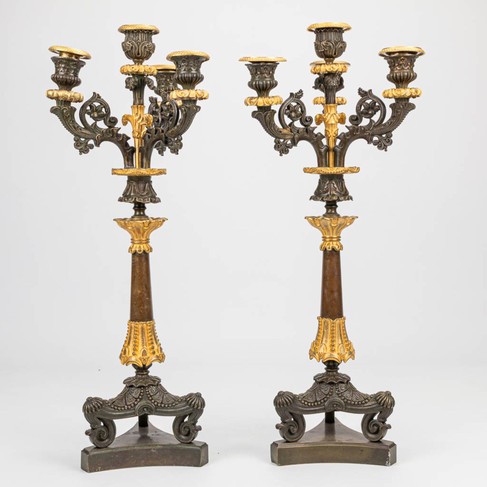 A pair of candelabra with gilt and patinated bronze in empire style, of the period. (16 x 20 x 51 cm