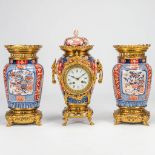 A 3 piece garniture clock made of Imari porcelain mounted with bronze. 19th century. (18,5 x 20 x 40