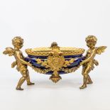 A table centrepiece consisiting of a porcelain bowl, carried by putti, decorated with garlands. 19th