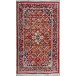 An Oriental hand-made carpet. Kerman with signature. (90 x 155 cm)