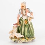 A faience group of an old lady with chicken, marked Capodimonte. (13 x 17 x 23 cm)