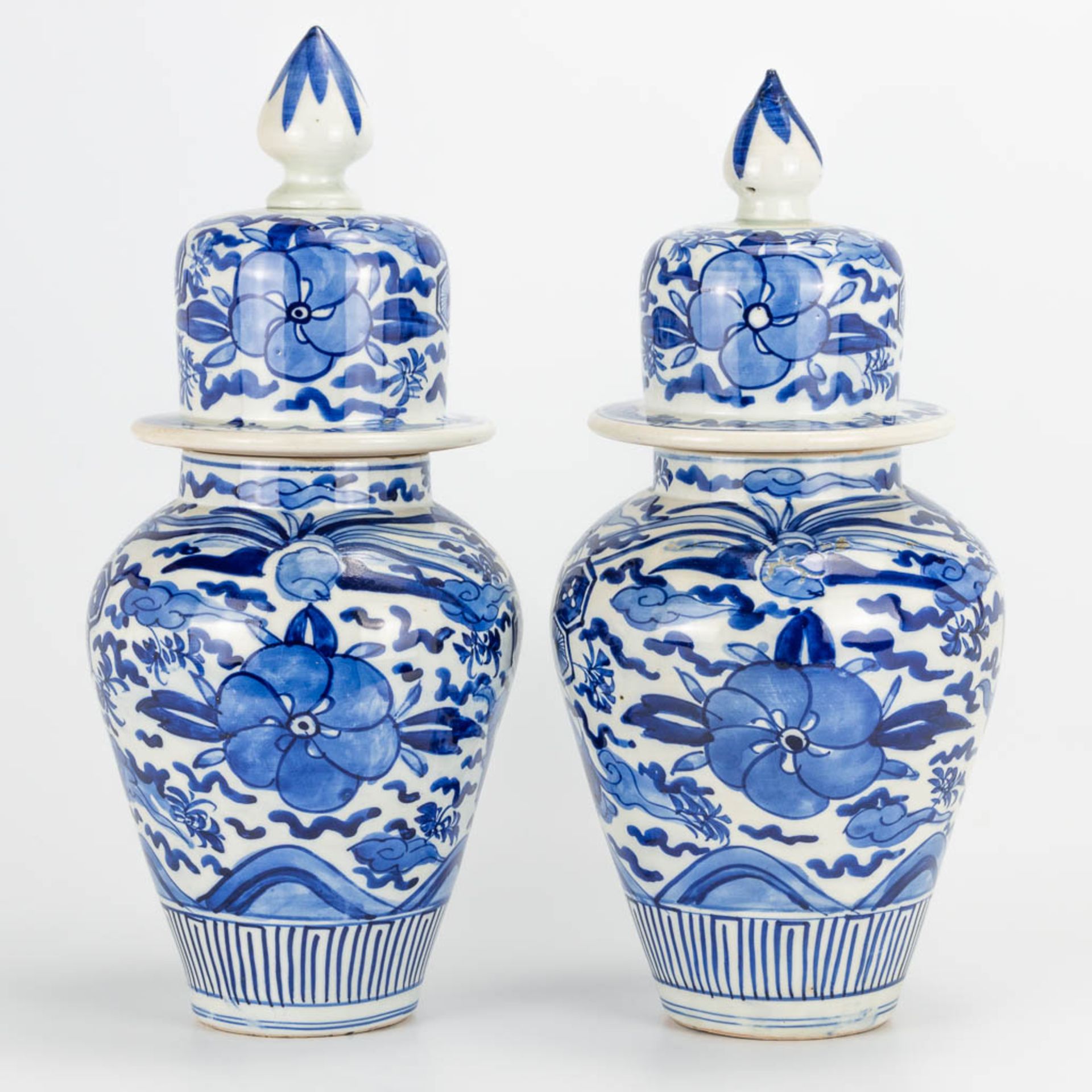 A pair of small Oriental vases wit lid, blue-white floral decor. (40 x 20 cm)