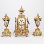 A three piece garniture clock made of bronze with porcelain. The second half of the 20th century. (1