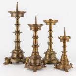 An assembled collection of bronze church candlesticks with bronze lion feet. 19th century. (38 x 17