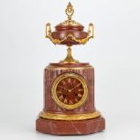 A clock made of red marble and mounted with ormolu bronze, Neoclassical style. The second half of th
