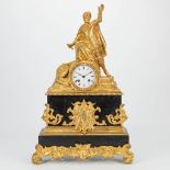 A mantle clock made of gilt bronze and marble with a knight statue. 19th century. (12,5 x 36 x 56 cm