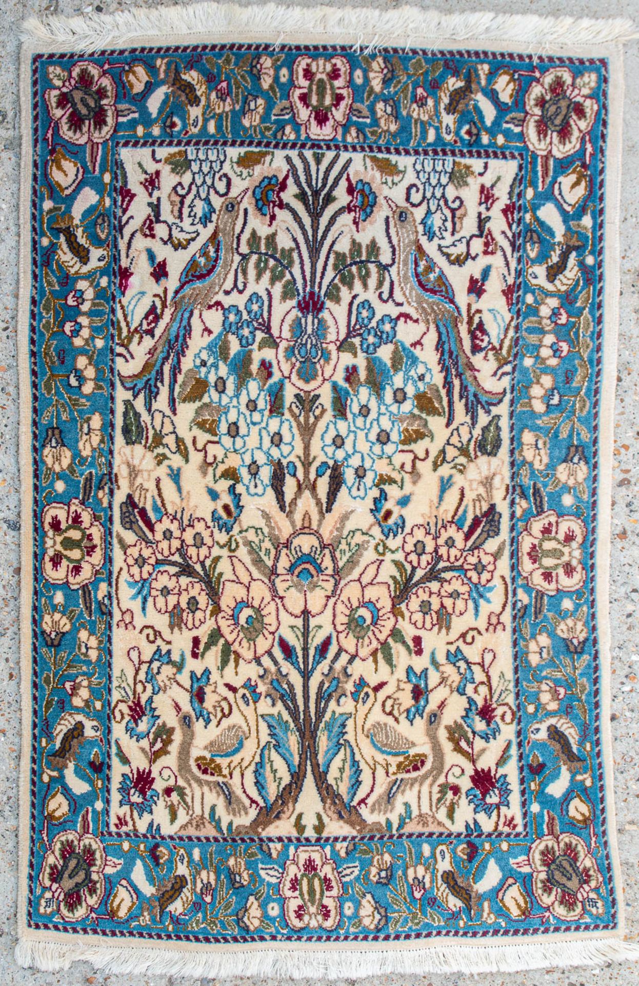 An Oriental hand-made carpet with birds. (83 x 129 cm)