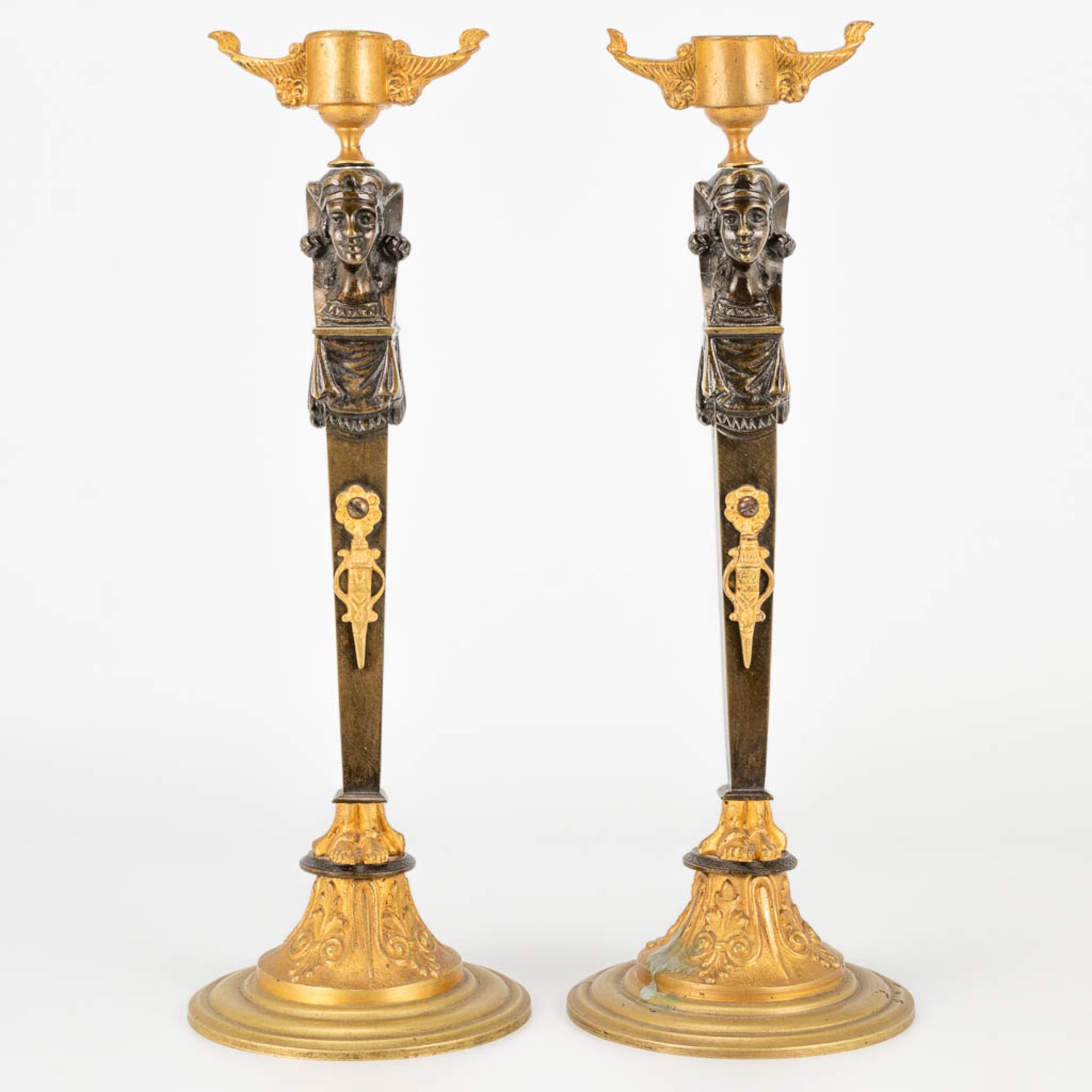 A pair of candlesticks made of gilt and patinated bronze in empire style. (27,5 x 9,5 cm)