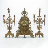 A 3 piece garniture clockset made of bronze, consisting of a clock and 2 candelabra. (18 x 35 x 52 c
