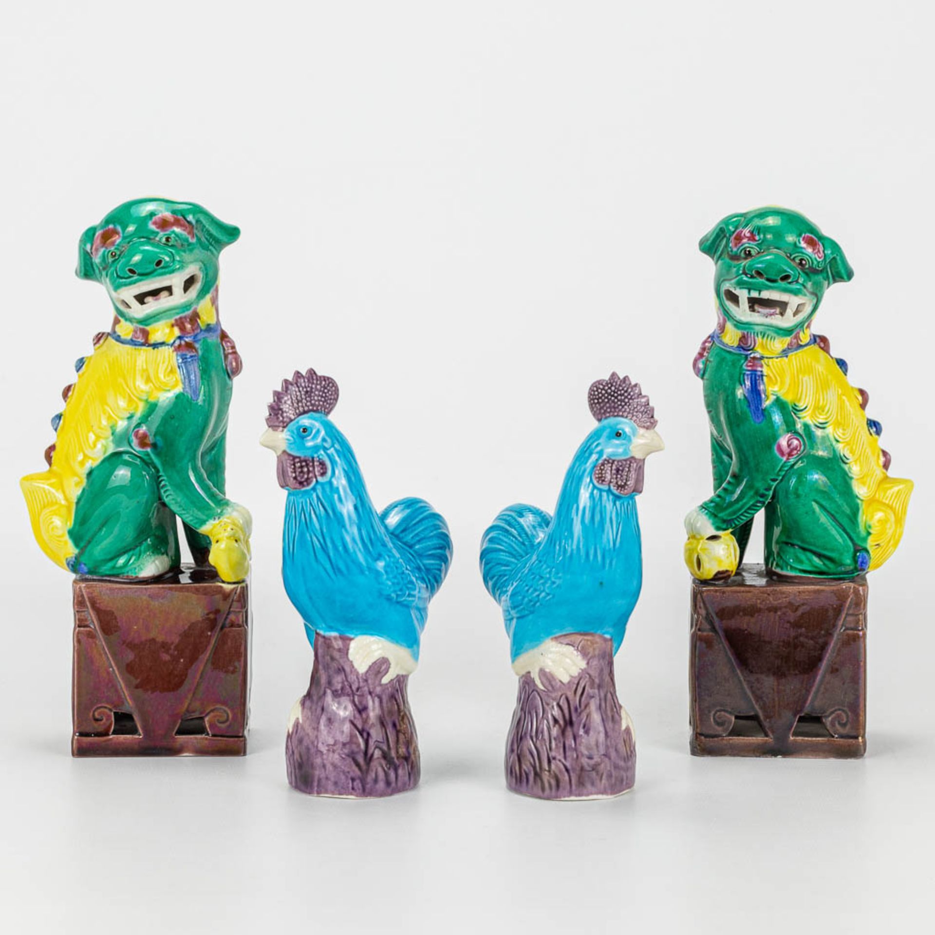A pair of Foo dogs and chicken made of Chinese porcelain.