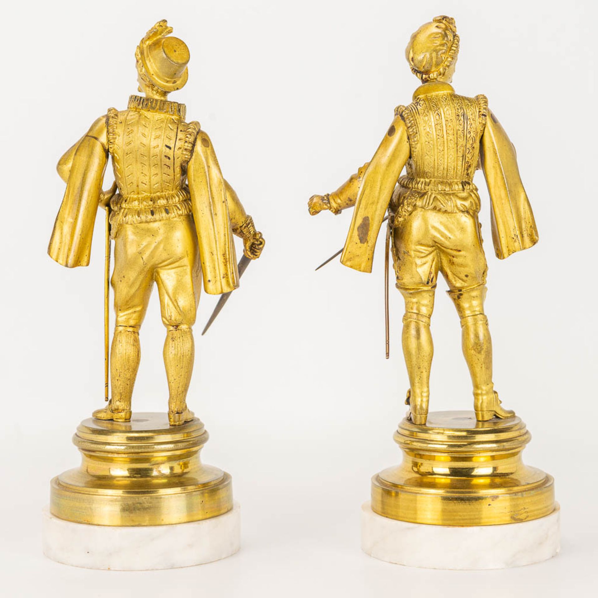 A pair of gilt Conquistadores statues made of gilt bronze and standing on a white marble base. - Image 7 of 9