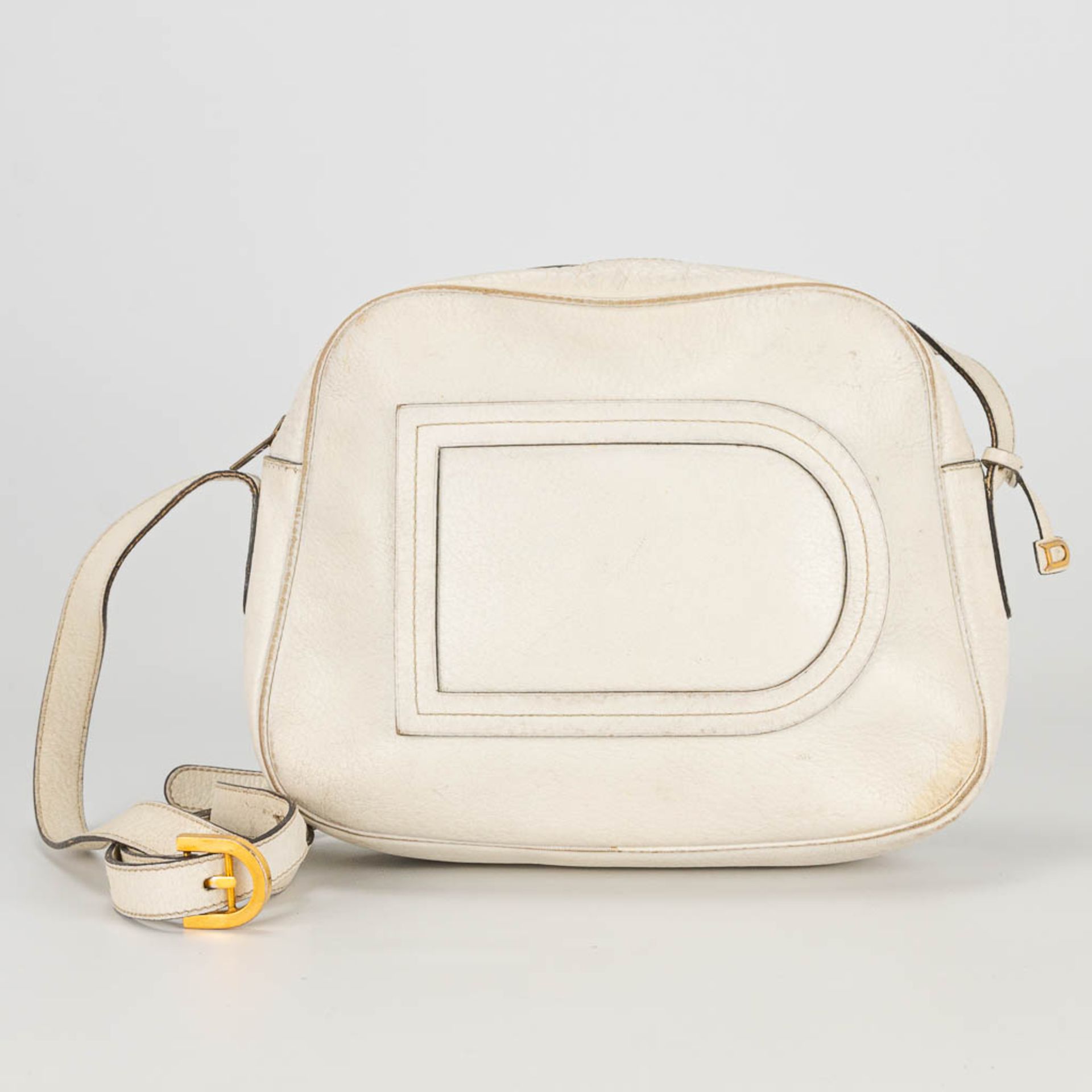 A purse made of white leather and marked Delvaux