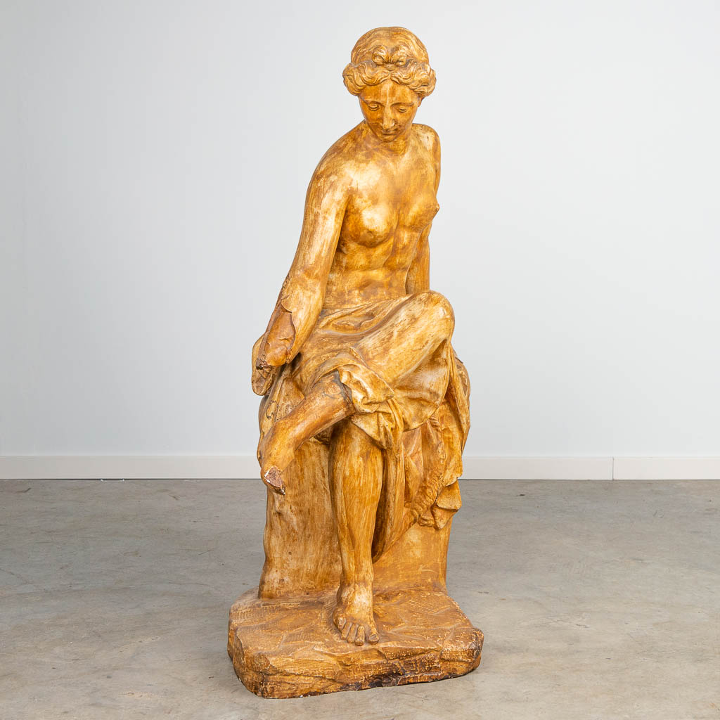 a large decorative statue of a seated lady, made of patinated plaster.