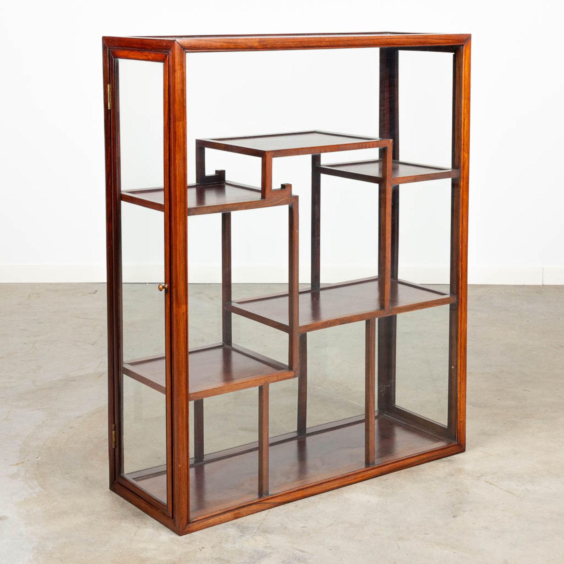 An Oriental display cabinet made of hardwood and glass.