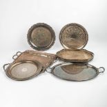 A collection of 7 serving trays made of silver-plated metal.