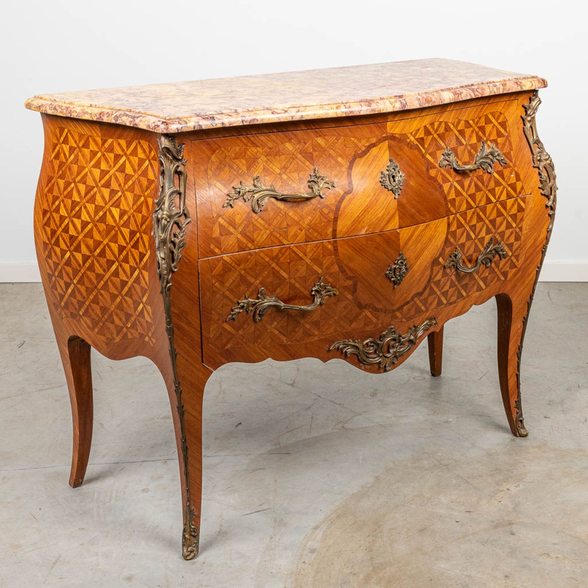A commode with a marble top and finished with bronze in Louis XV style.