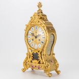 A table clock made of metal with bronze decorations in Louis XV style