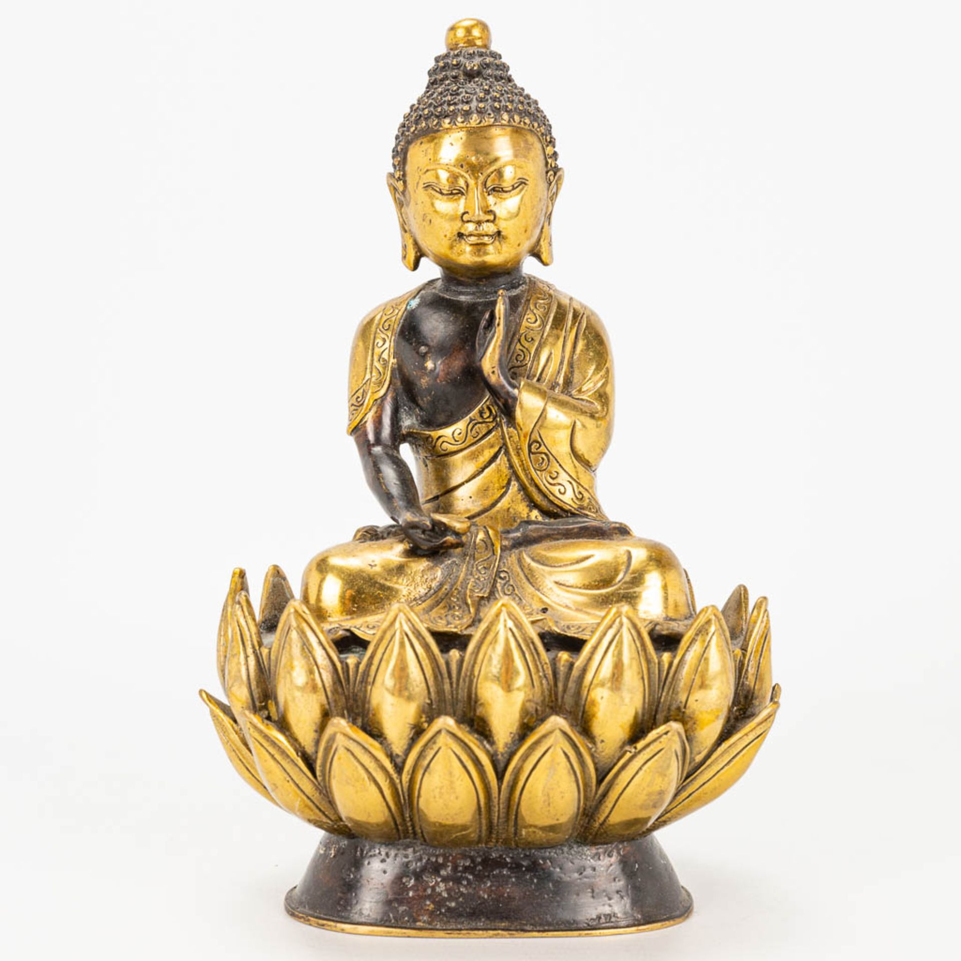 A Buddha on a lotus flower made of bronze.